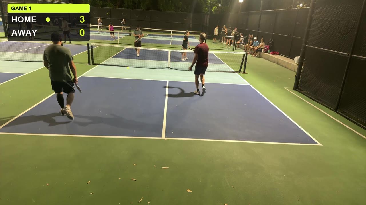 A real frame from a recorded night doubles game under court lights, with the CourtCast score bug reading Home 3, Away 0.